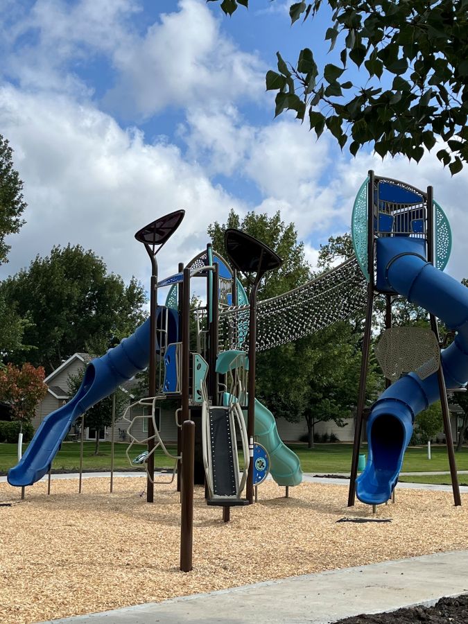 Blue and teal multi-level playground with tube slide and rope bridge 